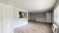 Located at 2 Lakeview Dr in Peekskill, NY, this well-appointed 2-bedroom, 1-bathroom home offers a thoughtfully designed layout across a single floor. The welcoming entrance opens into a spacious living room featuring light hardwood-style flooring, neutral gray walls, and a ceiling fan overhead. A pass-through window connects the living area to the kitchen, creating an open and communicative flow between the spaces. The kitchen is a standout feature, boasting dark shaker-style cabinetry, white quartz countertops, a marble-look tile backsplash, stainless steel appliances, and a window that brings in natural light. An adjacent dining or pass-through area includes a built-in shelf and electrical panel access. The two bedrooms are finished with light laminate flooring, neutral gray walls, natural light from windows, closets, and baseboard heating. A dedicated den provides additional flexible living space. The full bathroom is clean and modern, offering a tiled tub-and-shower combo, a floating vanity with a white countertop, and a small window. Additional highlights include a laundry area, a carpeted staircase with a dark handrail, and ample closet storage throughout.