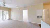 Located at 11390 US-19 N in Port Richey, Florida, this single-floor, one-bedroom, one-bathroom unit offers a well-organized and functional layout. The entrance leads into a kitchen equipped with white cabinetry, laminate countertops, a full suite of white appliances including a refrigerator, electric range, built-in microwave, and dishwasher, all set on durable wood-look flooring. The kitchen opens directly into a combined dining and living area finished with neutral carpet and crown molding, creating a cohesive and comfortable common space. A ceiling fan overhead and sliding glass doors leading to a private balcony allow for natural light and ventilation. The bedroom is a well-proportioned retreat featuring carpet flooring, a ceiling fan, and a window that invites abundant natural light. Six closets are distributed throughout the unit, providing exceptional storage capacity. The bathroom includes a single vanity with a wide mirror, tile flooring, and a full soaking tub with a shower. Warm beige tones, white trim, and consistent finishes throughout give the unit a clean, cohesive aesthetic. The balcony adds valuable outdoor living space to this efficiently designed Port Richey residence.