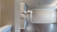 Located at 6303 SW Rutland Rd in Bentonville, Arkansas, this single-story residence offers a thoughtfully designed layout with a cohesive blend of modern finishes and comfortable living spaces throughout.

The open-concept living and dining area is anchored by rich wood-look flooring, crown molding, and a ceiling fan, creating a welcoming atmosphere. A kitchen pass-through connects seamlessly to the main living space, while the galley-style kitchen impresses with dark espresso cabinetry, granite countertops, stainless steel appliances including a refrigerator, range, and microwave, and a stainless undermount sink — all set atop matching wood-look flooring.

The bedrooms are carpeted for comfort and feature ceiling fans, generous windows that invite natural light and outdoor views, and mirrored sliding closet doors that maximize both storage and the sense of space. The bathrooms are well-finished, each showcasing dark cabinetry, granite vanity tops, large mirrors with contemporary lighting, and a tub-shower combination with tiled surrounds.

A central hallway connects the living areas to the private rooms, maintaining a practical and efficient flow throughout. The neutral color palette and consistent finishes lend the entire space a clean, modern aesthetic.