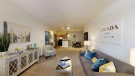 This single-floor residence at 9240 Brukhaus St in Raleigh, NC offers a well-designed open layout that connects the living, dining, and kitchen areas seamlessly. The spacious living room is finished with plush carpeting and features a set of French doors that invite natural light and provide access to the outdoors. The kitchen is equipped with warm wood cabinetry, granite countertops, black appliances including a range and refrigerator, and hardwood-style flooring that adds a clean contrast to the rest of the space. The dining area flows naturally from the kitchen, creating a comfortable space for everyday meals. The primary bedroom is a standout feature, boasting a ceiling fan, a softly colored accent wall, generous natural light from a large window, and a walk-in closet with built-in wire shelving. A second bedroom offers its own closet with sliding doors. The primary bathroom includes a dual-sink vanity with rich wood cabinetry, granite countertops, tile flooring, and a soaking tub. Throughout the space, neutral tones and consistent finishes create a cohesive, inviting ambiance suitable for comfortable everyday living.