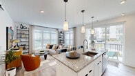 Located at 100 Dorchester Dr in Lumberton, NJ, this thoughtfully designed single-floor residence offers 2 bedrooms and 2 bathrooms within a comfortable and functional layout. The open-concept kitchen, dining, and living area forms the heart of the home, anchored by a granite-topped island with a stainless steel sink and stylish pendant lighting overhead. The kitchen is outfitted with white shaker cabinetry reaching to the ceiling, stainless steel appliances, and a classic subway tile backsplash, all set atop light-toned hardwood-style flooring that extends throughout the residence. The bright living room features expansive windows with views to the outdoors, filling the space with natural light and creating an airy, welcoming atmosphere. The primary bedroom is a generously sized retreat with a ceiling fan and access to a private en-suite bathroom, which includes a granite vanity and a glass-enclosed walk-in shower. The second bathroom features a full tub-shower combination. Additional highlights include five closets offering ample storage, a dedicated laundry area, a utility room, and two hallways connecting the well-organized floor plan. The overall aesthetic is clean and contemporary, with a neutral white palette, modern fixtures, and cohesive finishes throughout.