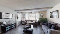 This single-story, 2-bedroom, 2-bathroom residence in Horn Lake, Mississippi offers a well-designed layout with comfortable living spaces throughout. The living room is an inviting, open area featuring wood-look plank flooring, a textured ceiling, ceiling fan with light, and multiple windows dressed with white sheer curtains and plantation shutters that allow abundant natural light to fill the space. A dedicated dining area adjoins the living space, highlighted by a pendant light fixture and wood-look flooring, providing an ideal setting for everyday dining. The galley-style kitchen is equipped with dark cabinetry, light countertops, a double-basin sink with a modern faucet, and black appliances including a range, refrigerator, and microwave. Both bedrooms feature plush carpeting and ceiling fans. The primary bedroom offers generous proportions, while the second bedroom includes a built-in desk area and floating shelves, making it versatile as a bedroom or home office. The two bathrooms each feature tub-shower combinations with curtains and wood-look flooring. One bathroom showcases a bold navy accent wall and a dark-framed vanity with a white countertop, adding a stylish contrast to the space.