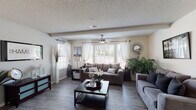This single-story, 2-bedroom, 2-bathroom residence in Horn Lake, Mississippi offers a well-designed layout with comfortable living spaces throughout. The living room is an inviting, open area featuring wood-look plank flooring, a textured ceiling, ceiling fan with light, and multiple windows dressed with white sheer curtains and plantation shutters that allow abundant natural light to fill the space. A dedicated dining area adjoins the living space, highlighted by a pendant light fixture and wood-look flooring, providing an ideal setting for everyday dining. The galley-style kitchen is equipped with dark cabinetry, light countertops, a double-basin sink with a modern faucet, and black appliances including a range, refrigerator, and microwave. Both bedrooms feature plush carpeting and ceiling fans. The primary bedroom offers generous proportions, while the second bedroom includes a built-in desk area and floating shelves, making it versatile as a bedroom or home office. The two bathrooms each feature tub-shower combinations with curtains and wood-look flooring. One bathroom showcases a bold navy accent wall and a dark-framed vanity with a white countertop, adding a stylish contrast to the space.
