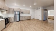 Located at 5625 S Hollywood Blvd in Las Vegas, NV, this single-story unit offers three bedrooms and one bathroom with a clean, modern aesthetic throughout. Light wood-style flooring runs continuously across all rooms, creating a cohesive and airy feel. The open-concept kitchen and living area forms the heart of the unit, featuring contemporary light wood cabinetry with ample upper and lower storage, white quartz-style countertops, and a full suite of stainless steel appliances including a gas range, dishwasher, refrigerator, and built-in microwave. Recessed lighting and a ceiling fan keep the space well-lit and comfortable. The three bedrooms are bright and neatly proportioned, each with large windows that invite natural light and offer views of the lush, palm-lined surroundings. The primary bedroom includes a ceiling fan for added comfort. The bathroom is finished with the same warm wood cabinetry, a wide vanity with white countertop, a large wall mirror, and a walk-in shower with tiled walls and built-in shelving. A dedicated closet, hallway, and well-organized layout round out this efficiently designed and move-in-ready Las Vegas residence.