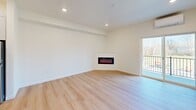This thoughtfully designed 2-bedroom, 2-bathroom apartment at 8005 NE 13th Ave in Vancouver, WA offers a clean, modern aesthetic throughout its single-floor layout. The open-concept living, dining, and kitchen area serves as the heart of the home, anchored by light wood-look flooring, recessed lighting, and a sleek wall-mounted electric fireplace. A sliding glass door leads to a private balcony with views of surrounding greenery, filling the living space with natural light. The kitchen is outfitted with stainless steel appliances, a subway tile backsplash, flat-front cabinetry with brushed gold hardware, and a generous island topped with striking veined quartz countertops that extend to the perimeter surfaces. Both bathrooms are finished with tile flooring, modern vanities, and tub-shower combinations featuring brushed nickel fixtures. The bedrooms are well-proportioned with light-filled windows offering outdoor views, light wood flooring, and ample closet space including walk-in options. Additional conveniences include an in-unit laundry area and a mini-split HVAC system. The overall ambiance is bright, clean, and contemporary, with a neutral palette that complements the modern finishes throughout.