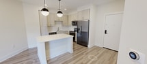 This contemporary 1-bedroom apartment in Durham, NC offers 600 square feet of efficient living space. The open-concept layout seamlessly blends the kitchen and living areas, creating a spacious feel. The kitchen boasts light-colored cabinetry, stainless steel appliances, and a central island, perfect for meal prep or casual dining.

The living area features wood-look flooring and connects to a private balcony through sliding glass doors, flooding the space with natural light. The bedroom, measuring 140 square feet, includes plush carpeting and ample closet space with wire shelving for organization.

The bathroom showcases modern fixtures and a glass-enclosed shower with white tile surrounds. Throughout the apartment, recessed lighting and a modern ceiling fan contribute to the overall ambiance. The neutral color palette and clean lines create a fresh, inviting atmosphere.

Additional amenities include in-unit laundry facilities and central air conditioning. Located at 3806 University Dr in Durham, this apartment offers a perfect blend of style and functionality for urban living.