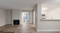 Located at 9933 Woodman Ave. in Mission Hills, California, this single-floor home offers four bedrooms and two bathrooms within a practical and well-organized layout. The combined living room and kitchen area serves as the heart of the home, featuring light wood-style laminate flooring, neutral warm-gray walls, and a textured ceiling throughout. A classic fireplace anchors the living area, adding character to the open space. A large window allows natural light to flow in, with views of the surrounding outdoor area.

The kitchen features crisp white cabinetry, a stainless steel microwave, a gas range, and a breakfast bar-style countertop that opens to the living area — ideal for casual dining and entertaining.

A central hallway connects the four bedrooms, each finished with plush carpet and closet storage. The primary bedroom includes a mirrored sliding closet and a window that brings in natural light. Additional bedrooms offer built-in closet rods and windows with outdoor views.

Both bathrooms are finished with wood-style flooring, a clean white vanity with a single sink and mirror, and an accessible tub/shower combination equipped with safety grab bars — making the space both functional and inclusive.