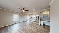 Located at 1361 Benbrook Boulevard in Huntsville, Alabama, this single-story home presents a thoughtfully designed open-concept layout finished with consistent, high-quality materials throughout. The living area flows seamlessly into the kitchen, unified by wood-look luxury vinyl plank flooring and crown molding that runs throughout the space. Multiple windows allow natural light to fill the interior, while recessed lighting and a ceiling fan with integrated lighting provide layered illumination.

The kitchen serves as a central hub of the home, featuring white shaker-style cabinetry, a striking granite-topped island, and matching granite countertops along the perimeter. Stainless steel appliances, a subway tile backsplash, a single-basin undermount sink with an oil-rubbed bronze faucet, and pendant lighting overhead complete this well-equipped space. Direct access to a dedicated laundry room with a full-size washer and dryer adds everyday convenience.

The primary bathroom offers a refined retreat, showcasing a freestanding soaking tub, a granite-topped vanity with an undermount sink, and oil-rubbed bronze fixtures throughout. A secondary full bathroom mirrors the same quality with a tub-shower combination, granite vanity, and coordinating hardware, ensuring a consistent aesthetic across the entire home.
