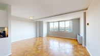 Located in the vibrant Dupont Circle neighborhood of Washington, DC, this efficiently designed residence offers a well-appointed single-floor layout comprising a living room, kitchen, and two bathrooms. The living room is a standout space, showcasing warm, checkerboard-pattern parquet wood flooring that adds a classic charm throughout. A large multi-pane window floods the room with natural light while framing picturesque views of the Washington, DC skyline, including notable architectural rooftops. Neutral gray walls and clean white ceilings provide a bright, versatile backdrop. The kitchen is thoughtfully equipped with white shaker-style cabinetry, dark granite countertops, and a full suite of stainless steel appliances, including a refrigerator, gas range, dishwasher, and built-in microwave. Light tile flooring completes the clean, functional aesthetic. The bathrooms continue the clean design language — one features a white vanity with dark granite countertop and tile flooring, while the other includes a full soaking tub with a tiled surround. A wall-mounted HVAC unit in the living area ensures year-round comfort. The overall ambiance is bright, practical, and well-suited for urban living in one of DC's most sought-after neighborhoods.
