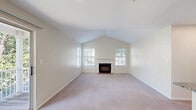 Located at 100 Christina Mill Dr in Newark, Delaware, this 2-bedroom, 2-bathroom single-floor home offers a well-designed layout with comfortable living spaces throughout. The living room is a standout feature, boasting soaring vaulted ceilings and a classic wood-burning fireplace framed by a white mantel and brick hearth. Flanking windows fill the room with natural light and provide views of the surrounding greenery, while plush carpeting adds warmth underfoot. The kitchen is thoughtfully appointed with white cabinetry, granite countertops, a white subway tile backsplash, and a full suite of stainless steel appliances including a range, microwave, and refrigerator. Tile flooring and an adjacent in-unit laundry area with a full-size washer and dryer add everyday convenience. The primary bedroom offers comfortable proportions, vaulted ceilings, a mirrored closet, and abundant natural light through an arched window. The second bedroom features carpet, a ceiling fan, and a standard closet. Both bathrooms are finished with granite-topped vanities, wood-look flooring, and clean white fixtures. Three closets throughout the home provide ample storage, rounding out this well-appointed residence.
