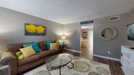 Located on Cantrell Road in Little Rock, Arkansas, this two-floor residence offers a well-organized and functional layout across multiple living spaces. The living room serves as a welcoming centerpiece, featuring warm neutral-toned walls, dark hardwood-style flooring, a textured ceiling, and ample room for comfortable seating arrangements. A staircase connects the two floors, and the entry area provides a natural transition into the main living space.

The kitchen is equipped with warm honey-toned wood cabinetry, light marble-patterned countertops, and white appliances including a range and dishwasher, all set atop durable wood-style flooring. Adjacent to the kitchen, the dining area accommodates a round dining table and is brightened by a sliding glass door fitted with vertical blinds, allowing natural light to filter through.

The bedrooms are carpeted for comfort and each features a ceiling fan with lighting. The bedrooms include closet space, with at least one room offering bifold closet doors and direct access to a shared bathroom. That bathroom presents a long vanity with wood cabinetry, light countertops, and a well-organized layout. Throughout the residence, a consistent gray color palette and cohesive design elements create a calm, unified ambiance.