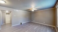 Located at 200 W Cranford Ave in Valdosta, Georgia, this efficient one-bedroom, one-bathroom unit is thoughtfully laid out across a single floor. The space features hardwood-style flooring throughout, neutral gray walls, and clean white trim, creating a modern and cohesive aesthetic.

The kitchen is a standout feature, outfitted with dark espresso cabinetry, granite countertops, and a full suite of stainless steel appliances including a refrigerator, dishwasher, electric range, and microwave. Crown molding and flush-mount ceiling lighting add a polished touch to the kitchen area.

The bedroom is comfortably sized and benefits from natural light through a window with blinds. A ceiling fan with integrated lighting provides both comfort and functionality. Built-in louvered bifold closet doors offer generous storage, while the room's neutral tones create a calm, restful atmosphere.

A hallway connects the main living areas to the bathroom, which includes a full tub-shower combo with chrome fixtures and a toilet, finished in neutral tones throughout.

The entryway features a six-panel door with decorative molding, opening into the main living and kitchen area. The unit combines practical storage solutions, updated finishes, and a functional layout suited for comfortable everyday living.