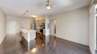 This contemporary 670 square foot apartment in Phoenix, AZ offers a thoughtfully designed living space. The open-concept layout maximizes the available area, creating a seamless flow between rooms. The apartment features a single bedroom measuring 140 square feet, providing a cozy retreat.

The kitchen is a highlight, boasting modern stainless steel appliances, including a refrigerator, microwave, and oven. Light-colored cabinetry and a white countertop island contribute to the kitchen's bright, airy feel. The living area connects directly to the kitchen, ideal for entertaining or casual dining.

Throughout the apartment, neutral tones dominate, with beige walls and carpeting in the bedroom, complemented by sleek hardwood floors in the main living areas. Large windows, including a sliding glass door leading to a small balcony, flood the space with natural light and offer city views.

The bathroom, while not extensively detailed, appears to be efficiently designed to maximize the apartment's compact footprint. Two closets provide ample storage space, a valuable feature in an urban dwelling.

Ceiling fans with integrated lighting fixtures add both functionality and style, enhancing the modern aesthetic. The overall design emphasizes clean lines and a minimalist approach, creating a space that feels larger than its actual square footage suggests.
