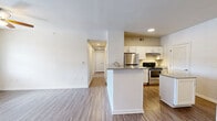 Located at 4730 N Nevada Ave in Colorado Springs, CO, this single-floor, three-bedroom, two-bathroom residence offers a well-designed layout with a clean, modern aesthetic throughout. The open-concept living and dining area flows seamlessly into the kitchen, which features white shaker-style cabinetry, granite countertops, stainless steel appliances including a range and refrigerator, and a peninsula with additional prep space. A louvered door off the kitchen leads to a dedicated laundry area. The living room is finished with wood-style flooring, a ceiling fan with light fixture, and a glass door that opens to a private balcony offering views of mature pine trees and the Colorado foothills beyond. The bedrooms are carpeted and well-lit, with the primary bedroom offering generous proportions and access to a walk-in closet equipped with wire shelving and a built-in shelving tower. The bathrooms mirror the kitchen's finishes, with granite vanity tops, white cabinetry, and wood-style flooring. Six total closets throughout the unit provide ample storage. The overall palette of warm neutrals, consistent finishes, and abundant natural light creates a bright, functional living environment well-suited for everyday comfort.