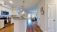 Located at 4000 Revere Blvd in Sherrills Ford, NC, this single-floor residence offers a thoughtfully designed open-concept layout with a cohesive blend of modern finishes and comfortable living spaces. Rich hardwood-style flooring flows throughout the main living areas, anchoring a bright and airy atmosphere.

The kitchen is well-appointed with white shaker cabinetry, granite countertops, a subway tile backsplash, and stainless steel appliances including a refrigerator, range, and over-the-range microwave. A peninsula with bar seating and elegant pendant lighting connects the kitchen to the living and dining areas. The dining nook sits just off the kitchen, offering an intimate space framed by warm décor and a decorative mirror accent.

The living room is spacious and light-filled, featuring French doors that invite natural light and provide outdoor access. A ceiling fan adds comfort to the relaxed, welcoming atmosphere.

Both bedrooms are carpeted and comfortably sized, each with ceiling fans and ample natural light from well-placed windows. The bathrooms are finished with tile flooring, granite-topped white vanities, and tub-shower combinations with classic subway tile surrounds. A wide hallway connects the private areas of the residence, maintaining a clean, functional flow throughout the home.