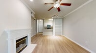 This two-story home offers a well-designed layout across two floors, combining comfort and functionality throughout its five bedrooms and three bathrooms. The main level features an open-concept kitchen and living room that serves as the heart of the home. The kitchen is outfitted with stainless steel appliances, granite countertops, white cabinetry, and a breakfast bar peninsula, while the living room showcases a classic fireplace, built-in shelving, crown molding, a ceiling fan, and light hardwood flooring. French doors in the living area invite natural light and provide a welcoming entry point. A hallway connects the main level, offering a clear view of the staircase leading to the upper floor. The bedrooms are carpeted and feature ceiling fans and windows that allow natural light to filter in. The primary bedroom is generously sized and is complemented by a walk-in closet with wire shelving for ample storage. The bathrooms are clean and functional, featuring tiled shower-tub combinations, granite vanity countertops, and light wood-style flooring. Two closets and a hallway round out the layout, providing practical storage and circulation throughout this well-appointed home.