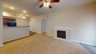 Located in Chatham, IL, this single-floor residence offers a thoughtfully designed layout that balances functionality and comfort throughout. The kitchen is a standout feature, equipped with rich cherry wood cabinetry, dark granite-style countertops, light wood-look vinyl flooring, and a full suite of black appliances including a refrigerator, electric range, and microwave. The open living area is warm and inviting, anchored by a built-in fireplace with a white surround and complemented by a ceiling fan with light fixture. The space flows naturally toward the kitchen, creating an interconnected gathering area. Multiple bedrooms are generously sized, each featuring plush neutral carpeting, ceiling fans, and windows that allow ample natural light. The bedrooms include closets with classic six-panel doors. The primary bathroom offers a rich cherry wood vanity with a large framed mirror, a tub/shower combination, and wood-look tile flooring. A second full bathroom mirrors the design with matching cabinetry, a tub/shower unit, and coordinating finishes. Neutral wall tones and consistent trim work throughout the home create a clean, cohesive aesthetic well-suited to a variety of décor styles.