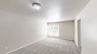 Located at 6200 Hightower Rd in Portsmouth, Virginia, this single-floor home offers four bedrooms, two bathrooms, and a practical layout designed for comfortable everyday living. The floor plan is efficiently organized, with hallways connecting the living areas to the bedrooms and shared spaces.

Each bedroom features plush wall-to-wall carpeting in neutral tones, clean white trim, and ceiling-mounted light fixtures. Several bedrooms include windows with blinds that allow natural light to filter in, offering views of surrounding greenery. At least one bedroom is notably spacious and includes a built-in closet with bifold doors, providing ample storage.

The galley-style kitchen is equipped with light grey cabinetry, a double-basin stainless steel sink, tile-patterned flooring, and includes a refrigerator and range. A doorway from the kitchen connects directly to additional rooms, enhancing flow throughout the home.

The bathrooms feature clean, white finishes, including a tiled tub-shower combination with chrome fixtures and a window for natural ventilation. A dedicated laundry room adds everyday convenience to the layout.

Throughout the home, neutral beige walls, white ceilings, and consistent carpeting create a cohesive and understated aesthetic, offering a move-in-ready canvas well-suited for a variety of living arrangements.