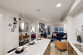 Located in the Laubman Street NW community of Edmonton, Alberta, this well-designed one-bedroom, one-bathroom unit offers a thoughtful open-concept layout across a single floor. The kitchen is a standout feature, showcasing two-tone cabinetry with white upper cabinets and warm wood-toned lower cabinets, quartz countertops, a subway tile backsplash, and a full suite of stainless steel appliances including a dishwasher, range, microwave, and refrigerator. A central island with pendant lighting provides additional prep space and doubles as a casual dining area. The kitchen flows seamlessly into the living room, which is brightened by large windows and a glass-panel exterior door that brings in natural light. Light-toned luxury vinyl plank flooring runs throughout, adding warmth and continuity to the space. The bedroom is a comfortable retreat with a wide window, ample closet storage, and a calm, neutral palette. The full bathroom features a tub-shower combo with clean white tile surround. Two closets and a dedicated laundry area add practical storage and everyday convenience, making this a well-appointed and efficiently designed home.