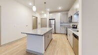 Located at 526 Summit Way in Mount Juliet, Tennessee, this single-floor residence offers a clean, contemporary design throughout its well-organized layout. The kitchen serves as a functional centerpiece, equipped with stainless steel appliances including a refrigerator, range, and microwave. Gray cabinetry with brushed nickel hardware pairs with granite countertops, and a central island provides additional workspace and storage. Pendant lighting and recessed fixtures illuminate the space effectively. Light wood-style flooring runs through the kitchen and main living areas, contributing to a bright, cohesive aesthetic.

The living area is open and well-lit, benefiting from a ceiling fan and a door that introduces natural light. Bedrooms feature plush carpeting, ceiling fans, and ample closet space, including a walk-in closet in at least one bedroom. Neutral wall tones throughout create a calm, versatile backdrop.

The bathrooms are finished with granite-topped vanities, gray cabinetry, undermount sinks, framed mirrors, and light wood-style flooring. One bathroom includes accessibility-friendly grab bars. Overall, the space presents a modern, functional environment with consistent finishes and a neutral, move-in-ready aesthetic.