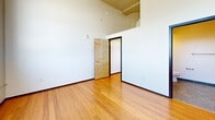 Suite 509 at 675 N Main St offers an impressive urban loft aesthetic in the heart of Winston-Salem, NC. Soaring ceilings and large industrial-style windows flood the open living area with natural light, while warm bamboo hardwood floors run throughout. The kitchen features rich dark wood cabinetry, granite countertops, stainless steel appliances, and a breakfast bar. The spacious bedroom includes a generous walk-in closet with built-in shelving. Three bathrooms are finished with slate tile flooring and granite accents. Exposed ductwork and wall sconce lighting add to the industrial-chic character of this distinctive urban residence.