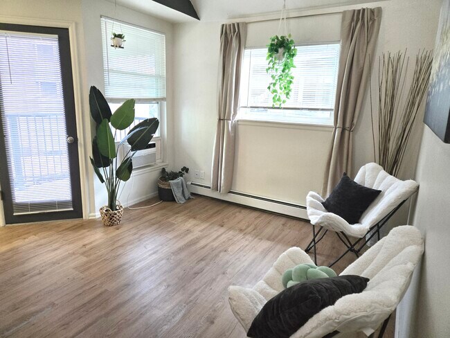 Sala de estar con puerta que da a una terraza orientada al sur/suroeste. Es una unidad esquinera, por lo que las ventanas dan al sur y al oeste. - 1830 22nd St