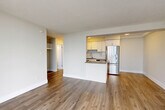 Located on the 15th floor at 151 Keith Rd E in North Vancouver, this one-bedroom, one-bathroom unit offers a well-designed layout with a bright, open feel throughout. The combined kitchen and living area forms the heart of the home, featuring warm hardwood-style flooring, white textured ceilings, and a clean, neutral colour palette. The kitchen is equipped with stainless steel appliances — including a refrigerator, range, and over-the-range microwave — complemented by white cabinetry, a subway tile backsplash, dark countertops, and a peninsula that doubles as a breakfast bar. A dedicated pantry provides additional storage. The living area opens to a private balcony through floor-to-ceiling sliding glass doors, framing impressive views of the surrounding mountains and North Vancouver cityscape. The bedroom is a comfortable size, benefiting from a large window that fills the room with natural light, and is serviced by two closets. The bathroom features classic white subway tile surrounds on the tub-shower, a dark-toned vanity with a light countertop, and chrome fixtures. A well-organized hallway with built-in storage connects the spaces efficiently, completing this functional and attractive North Vancouver residence.