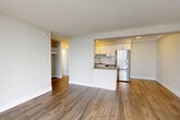 Located on the 15th floor at 151 Keith Rd E in North Vancouver, this one-bedroom, one-bathroom unit offers a well-designed layout with a bright, open feel throughout. The combined kitchen and living area forms the heart of the home, featuring warm hardwood-style flooring, white textured ceilings, and a clean, neutral colour palette. The kitchen is equipped with stainless steel appliances — including a refrigerator, range, and over-the-range microwave — complemented by white cabinetry, a subway tile backsplash, dark countertops, and a peninsula that doubles as a breakfast bar. A dedicated pantry provides additional storage. The living area opens to a private balcony through floor-to-ceiling sliding glass doors, framing impressive views of the surrounding mountains and North Vancouver cityscape. The bedroom is a comfortable size, benefiting from a large window that fills the room with natural light, and is serviced by two closets. The bathroom features classic white subway tile surrounds on the tub-shower, a dark-toned vanity with a light countertop, and chrome fixtures. A well-organized hallway with built-in storage connects the spaces efficiently, completing this functional and attractive North Vancouver residence.