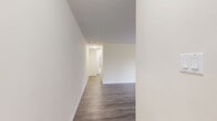 Located at 53 Mcmurchy Ave N in Brampton, Ontario, this 2-bedroom, 1-bathroom unit offers a well-organized and functional layout across a single floor. The living room is generously proportioned, featuring grey laminate wood flooring and soft, neutral-toned walls that create a clean and welcoming atmosphere. Large sliding doors open directly onto a private balcony, where residents can enjoy views of lush greenery, mature trees, and well-maintained lawns — a refreshing outdoor retreat.

Both bedrooms continue the cohesive aesthetic with matching laminate flooring and warm beige walls. The primary bedroom includes a window overlooking the surrounding building exterior, while the second bedroom features a built-in sliding-door closet, offering practical storage. Each room benefits from natural light and baseboard heating units.

The bathroom is finished with light ceramic tile flooring and beige tile surround in the tub-shower combination, complemented by a clean white vanity and toilet. The overall design is straightforward and functional.

The unit's two balconies — one facing green space and another with a street-level tree-lined view — add to the appeal of this well-maintained residential space in a landscaped community setting.