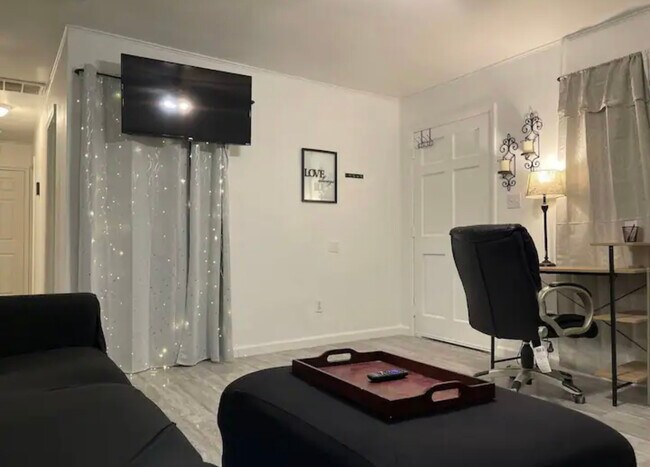 Living room with large sectional and smart TV and desk area with LED light and remote for different - 805 Briarwood Rd