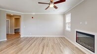 Located in D'Iberville, Mississippi, this single-story home offers a thoughtfully designed layout across two bedrooms and two full bathrooms. The open-concept kitchen and living area serves as the heart of the home, featuring a peninsula with pendant lighting, white shaker cabinetry, stainless steel appliances, and light wood-tone flooring that flows throughout the main living spaces. Natural light pours in through multiple windows, including a charming bay window near the entryway, which is framed by a classic paneled door with a transom window above.

The spacious primary bedroom is carpeted and includes a ceiling fan, a dedicated closet with wire shelving, and ample room to furnish comfortably. The second bedroom also features plush carpeting, a ceiling fan, and a window with natural light. Both bathrooms are finished with white cabinetry, undermount sinks, brushed nickel fixtures, and wood-look flooring; one includes a full tub-shower combination. Each bedroom benefits from its own closet with built-in wire shelving systems. The home also includes an attached garage with a standard roll-up door, offering convenient covered parking and additional storage potential. Crown molding and neutral warm-toned walls contribute to a clean, cohesive aesthetic throughout.