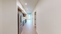 Located at 440 W Columbia Way in Vancouver, WA, this modern apartment offers a thoughtfully designed layout across a single floor, accommodating three bedrooms, one bathroom, and a dedicated kitchen. Light wood-toned flooring runs throughout, creating a warm and cohesive aesthetic that complements the crisp white walls.

The kitchen is a standout feature, outfitted with warm wood cabinetry, white quartz countertops, a vertical subway tile backsplash, open shelving, a deep single-basin sink with a matte black faucet, and a full suite of stainless steel appliances including a French door refrigerator and dishwasher. Recessed lighting enhances the functional workspace.

The spacious primary bedroom features an exposed concrete ceiling that adds an industrial character, large windows that invite abundant natural light, and views of the surrounding Vancouver cityscape and greenery. A wall-mounted mini-split system provides climate control. The two additional bedrooms are bright and well-proportioned, each with large windows framing outdoor views. One bedroom features a stylish black-hardware sliding barn door for closet access.

The bathroom is clean and modern, with wood-toned cabinetry, white countertops, matte black fixtures, and a generous layout. A dedicated closet and a well-connected hallway complete this efficiently designed home.
