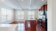 Located at 124 Cabot Alley in Mechanicsburg, Pennsylvania, this three-bedroom, two-bathroom residence is thoughtfully organized across three floors. The ground level features a garage with a concrete floor and standard overhead door, providing secure parking and additional storage space.

The main living floor offers a generously sized open layout with plush carpeting, multiple windows that draw in natural light, and a staircase with a wood railing. The kitchen is a standout feature, showcasing rich cherry wood cabinetry with crown molding detail, a large granite-topped island with a built-in sink, hardwood flooring, and black Whirlpool appliances including a side-by-side refrigerator, electric range, and over-the-range microwave.

The upper floor houses all three bedrooms, including a spacious primary bedroom with a walk-in closet fitted with wire shelving systems. The additional bedrooms feature plush carpeting and double-door closets. Two full bathrooms serve the upper level, each equipped with a tub-shower combination and clean, neutral finishes. Throughout the home, neutral wall tones and consistent trim work create a cohesive and functional living environment.