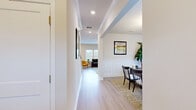 Located on East Old Hickory Boulevard in Nashville, TN, this two-story, 4-bedroom, 4-bathroom home offers a well-organized layout across two distinct floors. The main level features light hardwood-style flooring throughout, connecting a combined kitchen and living room, a formal dining room, and two hallways that guide traffic efficiently through the space. The kitchen is equipped with white shaker cabinetry extending to the ceiling, granite countertops, and stainless steel appliances including a side-by-side refrigerator. The dining room is highlighted by wainscoting, a chandelier, and natural light from large windows. A dedicated laundry room and full bathroom round out the main floor. Upstairs, the more expansive floor houses all four bedrooms, including a generously sized primary suite featuring a tray ceiling with crown molding, plush carpeting, and a walk-in closet with natural light. The additional bedrooms are carpeted and well-proportioned, served by the remaining bathrooms. Throughout the home, a neutral color palette, recessed lighting, and clean architectural details create a bright, cohesive aesthetic suited for comfortable everyday living.