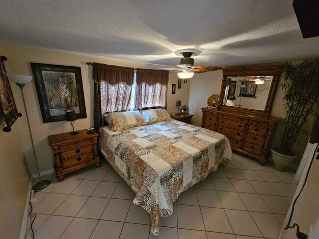 Dormitorio principal con cómoda y armario a juego. Televisor montado en la pared. - 3931 Sail Dr