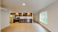 This well-appointed single-story home in Vancouver, Washington offers a thoughtfully designed layout with one bedroom, three bathrooms, and a generous open-concept living space. Light wood-tone flooring flows seamlessly throughout, creating a cohesive and modern aesthetic.

The kitchen is a standout feature, showcasing rich dark walnut cabinetry with recessed lighting, a white subway tile backsplash, white quartz countertops, and a full suite of stainless steel appliances including a range, microwave, dishwasher, and refrigerator. The kitchen opens directly into the combined dining and living area, which benefits from large windows that bring in abundant natural light and views of the surrounding neighborhood.

The primary bedroom is comfortably sized, featuring two windows and direct access to a dedicated closet and a private bathroom. The bathrooms are clean and modern, with gray vanity cabinetry, white countertops, brushed nickel fixtures, and a walk-in shower with a rainfall showerhead.

Additional highlights include a dedicated laundry area with a stacked washer and dryer tucked behind louvered doors, a pantry for added storage, an entrance foyer, and an outdoor patio. The overall design is bright, clean, and move-in ready.
