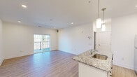 Located at 111 Sunset Circle in Camden, Delaware, this well-appointed one-bedroom, one-bathroom residence offers a thoughtfully designed single-floor layout. The open-concept kitchen and living area serves as the heart of the home, featuring light wood-style flooring, recessed lighting, and pendant lights above a central island. The kitchen is outfitted with white shaker cabinetry, granite countertops, a subway tile backsplash, and a full suite of stainless steel appliances, including a refrigerator, range, and microwave. The living area flows naturally toward sliding glass doors that open onto a private balcony, bringing in generous natural light and outdoor views of surrounding trees. The spacious bedroom is finished with plush carpeting, a ceiling fan, and a window that further brightens the room, with ample storage provided by three closets throughout the unit. The full bathroom features a clean, modern aesthetic with a soaking tub and shower combo, white vanity with a countertop sink, wood-style flooring, and brushed nickel fixtures. A dedicated laundry area adds everyday convenience. The overall design is bright and neutral throughout, creating a clean and move-in-ready living environment.