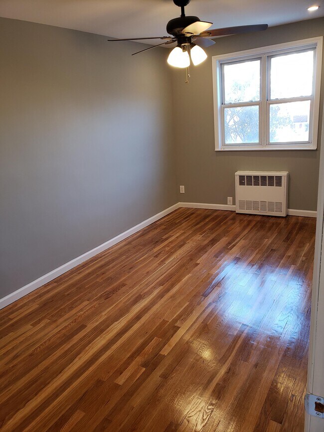 Habitación con cama tamaño queen y luz natural. - 761 E 101st St