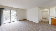 Located in Lorton, Virginia, this single-floor unit offers four bedrooms and two full bathrooms across a well-utilized floor plan. The galley-style kitchen is equipped with warm oak cabinetry, light countertops, a white appliance suite including a refrigerator, electric range, and dishwasher, and durable tile flooring. A pass-through countertop bar connects the kitchen to the living area, enhancing the open flow between spaces. The living area features plush carpeting and a ceiling fan, with a sliding glass door that opens onto a private balcony overlooking the surrounding community. The primary bedroom is a comfortable size with a window that brings in natural light and ample room for furnishings. The three additional bedrooms are carpeted and well-proportioned, each offering good natural light. Two full bathrooms are finished with white tile tub-and-shower combinations, light countertops, wood-toned vanity cabinetry, and tile flooring. Two closets provide convenient storage throughout the unit. The overall aesthetic is clean and neutral, with white walls and consistent finishes that offer a move-in-ready canvas. The entry foyer features hardwood-style flooring, adding a welcoming touch at the front door.