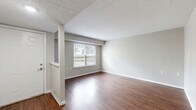 This two-story, three-bedroom, two-bathroom home in Troy, Ohio offers a practical and well-organized layout across two floors. The main level features warm wood-look hardwood flooring throughout the living room and kitchen areas, neutral-toned walls, and a textured ceiling. The living room is bright and open, with a front-facing window that brings in natural light and a staircase leading to the upper level. The kitchen is equipped with warm oak cabinetry, a white electric range, a refrigerator, a double-basin sink, and ample counter space, along with a large closet for additional storage. A bathroom on the main level includes hardwood-style flooring, a vanity with wood cabinetry, and a tub-shower combination. Upstairs, three carpeted bedrooms each feature ceiling fans with light fixtures and windows providing natural light. The primary bedroom includes a dedicated walk-in closet, offering generous storage. The additional bedrooms are well-proportioned and share a second full bathroom. Throughout the home, a consistent neutral color palette and clean finishes contribute to a simple, functional aesthetic well-suited for comfortable everyday living.