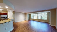 This single-floor residence offers a thoughtfully designed layout that balances open living spaces with well-appointed private rooms. The expansive living area is anchored by warm hardwood flooring that extends throughout the main living spaces, complemented by large windows that frame outdoor greenery and flood the interior with natural light. A track lighting system provides additional illumination, while a dedicated HVAC vent ensures year-round comfort.

The kitchen is outfitted with rich cherry wood cabinetry, gleaming granite countertops, and a full suite of stainless steel appliances, including a refrigerator, electric range, and built-in microwave. A double undermount sink and decorative column detail add functional and architectural interest. The kitchen opens conveniently to the main living area.

The bedrooms feature plush carpeting and ceiling fans, with windows providing natural light and outdoor views. Closet space is well-distributed, with built-in shelving for organized storage.

The bathrooms are finished with granite-topped vanities and rich wood cabinetry. The full bathroom features floor-to-ceiling tile work with a decorative border accent and a soaking tub, while the second bathroom offers a clean, compact design with a walk-in shower.