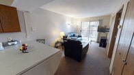 Located at 110 E Armory Ave in Champaign, Illinois, this single-floor unit offers a practical and functional layout well-suited for everyday living. The living room serves as the central gathering space, featuring carpet flooring, wall-mounted lighting, and a sliding glass door that opens to a balcony, allowing natural light to fill the room and providing views of the surrounding neighborhood.

The kitchen is efficiently designed with tile flooring and includes stainless steel appliances — a side-by-side refrigerator, electric range, and over-the-range microwave — complemented by warm wood cabinetry that provides ample storage. A sink with under-cabinet space completes the functional cooking area.

The unit includes multiple bedrooms, each carpeted and fitted with windows that bring in natural light. Several bedrooms feature built-in or sliding-door closets with shelving, offering practical storage solutions. One bedroom also includes wall-mounted shelving, adding additional organization options.

The bathroom features tile flooring, a shower-tub combination, and direct access to an adjoining bedroom, contributing to a convenient layout. Overall, the unit presents a straightforward, no-frills living environment with essential amenities throughout.