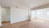 Located at 114 Auston Woods Cir in Easley, South Carolina, this single-floor, one-bedroom, one-bathroom home offers a practical and comfortable layout. The open living room flows seamlessly into the dining and kitchen area, creating a connected, easy-to-navigate floor plan. Soft, neutral carpeting runs throughout the living and bedroom areas, while the kitchen features durable tile-style flooring. The kitchen is equipped with warm wood-toned cabinetry, a white electric range, refrigerator, dishwasher, and a double-basin sink beneath overhead cabinet storage. The living area benefits from vaulted ceiling accents and an open pass-through to an additional sun-filled space, where multiple windows invite an abundance of natural light. The bedroom is a comfortable, well-proportioned room with a large window offering outdoor views and a dedicated closet with built-in shelving and hanging rods. The bathroom includes a full tub and shower combination with clean white surround. An in-unit laundry area with washer hookups adds everyday convenience. Clean white walls throughout give the home a bright, move-in-ready feel, making it a practical choice in the Easley, SC community.