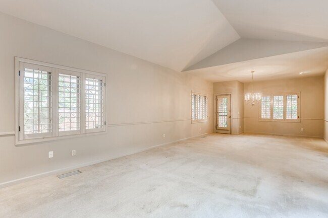 Open living and dining room with a door to the patio - 2552 E Alameda Ave