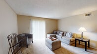 This single-story unit in Memphis offers a practical and comfortable layout designed to maximize functionality. The living room serves as the central gathering space, featuring plush wall-to-wall carpeting, warm neutral-toned walls, and a textured ceiling. A large sliding glass door fitted with vertical blinds fills the room with natural light and connects to the adjacent dining area, which flows seamlessly into the rest of the unit.

The galley-style kitchen is efficiently designed with warm oak cabinetry lining both sides, offering ample storage space. White appliances, including a range, refrigerator, and dishwasher, are complemented by light countertops and tile flooring, creating a clean and cohesive look.

The bedroom is generously sized, accommodating a full bedroom set comfortably. Soft carpet, neutral walls, and windows with blinds provide a calm, restful environment with natural light.

The full bathroom features tile flooring, a tub-shower combo with white tile surround, a single-sink vanity with oak cabinetry, and a large mirror. A dedicated laundry area with built-in shelving provides added convenience, housing a full-size washer and dryer within a tiled utility space.