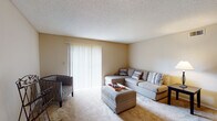 This single-story unit in Memphis offers a practical and comfortable layout designed to maximize functionality. The living room serves as the central gathering space, featuring plush wall-to-wall carpeting, warm neutral-toned walls, and a textured ceiling. A large sliding glass door fitted with vertical blinds fills the room with natural light and connects to the adjacent dining area, which flows seamlessly into the rest of the unit.

The galley-style kitchen is efficiently designed with warm oak cabinetry lining both sides, offering ample storage space. White appliances, including a range, refrigerator, and dishwasher, are complemented by light countertops and tile flooring, creating a clean and cohesive look.

The bedroom is generously sized, accommodating a full bedroom set comfortably. Soft carpet, neutral walls, and windows with blinds provide a calm, restful environment with natural light.

The full bathroom features tile flooring, a tub-shower combo with white tile surround, a single-sink vanity with oak cabinetry, and a large mirror. A dedicated laundry area with built-in shelving provides added convenience, housing a full-size washer and dryer within a tiled utility space.