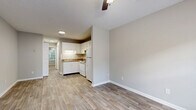 Located at 1202 Old Lascassas Rd in Murfreesboro, Tennessee, this efficient one-bedroom, one-bathroom unit offers a well-organized single-floor layout. The living area greets you with wood-look plank flooring, neutral gray walls, and a ceiling fan, creating a bright and airy atmosphere. Natural light filters in through a window overlooking greenery, adding a touch of the outdoors to the interior. The kitchen is positioned adjacent to the living space and features white cabinetry, a white appliance suite including a range and refrigerator, a single-basin sink with warm-toned countertops, and under-cabinet lighting — all contributing to a clean, functional workspace. A hallway connects the main living area to the private bedroom and bathroom. The bedroom is carpeted for comfort, finished with neutral walls, a ceiling fan with light fixture, and a window that brings in natural light and outdoor views. The bathroom includes a white vanity with a granite-style countertop and integrated sink, a standard toilet, a shower/tub combination, and consistent wood-look flooring that ties the space together. Throughout the unit, clean white trim, a neutral color palette, and consistent finishes create a cohesive and practical living environment.
