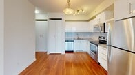 Located on the 10th floor at 1215 5th St SW in Calgary's vibrant Beltline neighbourhood, this two-bedroom, one-bathroom unit offers a well-designed layout across a single floor. Warm hardwood flooring runs throughout the main living areas and bedrooms, creating a cohesive and inviting atmosphere.

The kitchen is a functional highlight, featuring sleek white gloss cabinetry, stone countertops, a glass tile backsplash, and a full suite of stainless steel appliances including a double oven range, built-in microwave, dishwasher, and full-size refrigerator. Ample upper and lower storage, along with open shelving, maximizes the use of space efficiently.

The bedrooms are bright and airy, with the primary bedroom benefiting from floor-to-ceiling windows that frame striking views of the Calgary skyline and surrounding urban landscape. The elevated position of the unit ensures an impressive and unobstructed city panorama.

The bathroom is clean and modern, finished with large-format grey tile flooring, a wood-toned vanity with an undermount sink, white countertop, and a full bathtub. The crisp white walls and well-placed lighting keep the space feeling bright and fresh.

Additional built-in storage and closet space are thoughtfully integrated throughout the unit, making this a practical and polished urban residence.