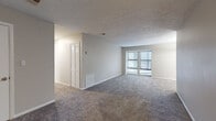 This single-floor residence offers a thoughtfully laid-out floor plan that balances open living spaces with comfortable private areas. The expansive main living area is finished with plush carpeting and neutral-toned walls, creating a bright and versatile space. A large double-pane window allows natural light to fill the room, while a louvered closet door adds a classic touch. The textured ceiling is consistent throughout the common areas, lending a cohesive feel to the space.

The kitchen is appointed with crisp white shaker-style cabinetry, granite-style countertops, and a black electric range with an overhead exhaust hood. Light wood-look flooring ties the kitchen together with a clean, modern aesthetic.

Multiple bedrooms are carpeted and feature neutral wall tones, textured ceilings, and windows with blinds that invite natural light. Each room offers ample space and multiple electrical outlets for flexible furniture arrangements.

The bathrooms are finished with light wood-look flooring, white vanity cabinetry, granite-style countertops, and framed mirrors with modern vanity lighting. One bathroom includes a full tub and shower combination, while another features a separate water closet layout for added privacy and functionality. Together, the rooms create a comfortable and move-in-ready living environment.