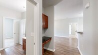 Located at 2500 McArthur Landing Circle in Fayetteville, NC, this well-appointed 2-bedroom, 2-bathroom single-floor home offers a comfortable and functional layout. The open-concept kitchen and living area serves as the heart of the home, featuring warm wood-toned cabinetry, dark granite-style countertops, a breakfast bar peninsula, and black appliances including a refrigerator, range, microwave, and dishwasher. A tiled backsplash and hardwood-style flooring carry throughout the kitchen and living spaces, complemented by a pendant chandelier that adds a touch of elegance to the dining area. The living room extends the open feel with wood-style flooring, neutral gray walls, and ceiling fans for year-round comfort. Both bedrooms are carpeted and bathed in natural light through window blinds with outdoor views of greenery. The primary bedroom offers a generous footprint, while the second bedroom also includes a ceiling fan. Each bathroom is clean and functional — one features a full soaking tub/shower combo, while both include warm wood vanities with ample counter space. A dedicated laundry area houses a full-size washer and dryer with overhead shelving. A separate closet provides additional storage throughout this efficiently designed home.